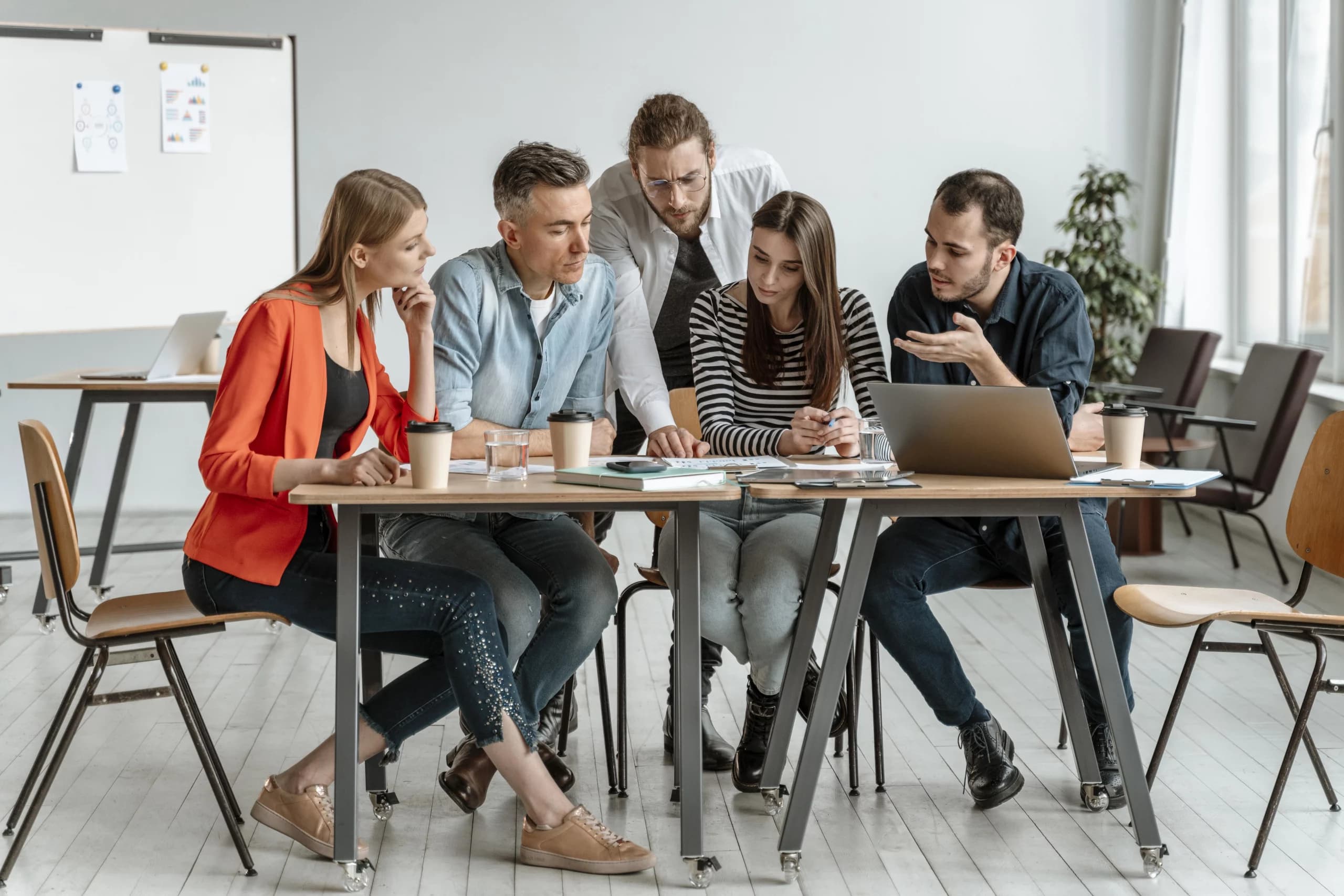 Une formatrice Qualiopi échange avec deux professionnels sur leur certification.