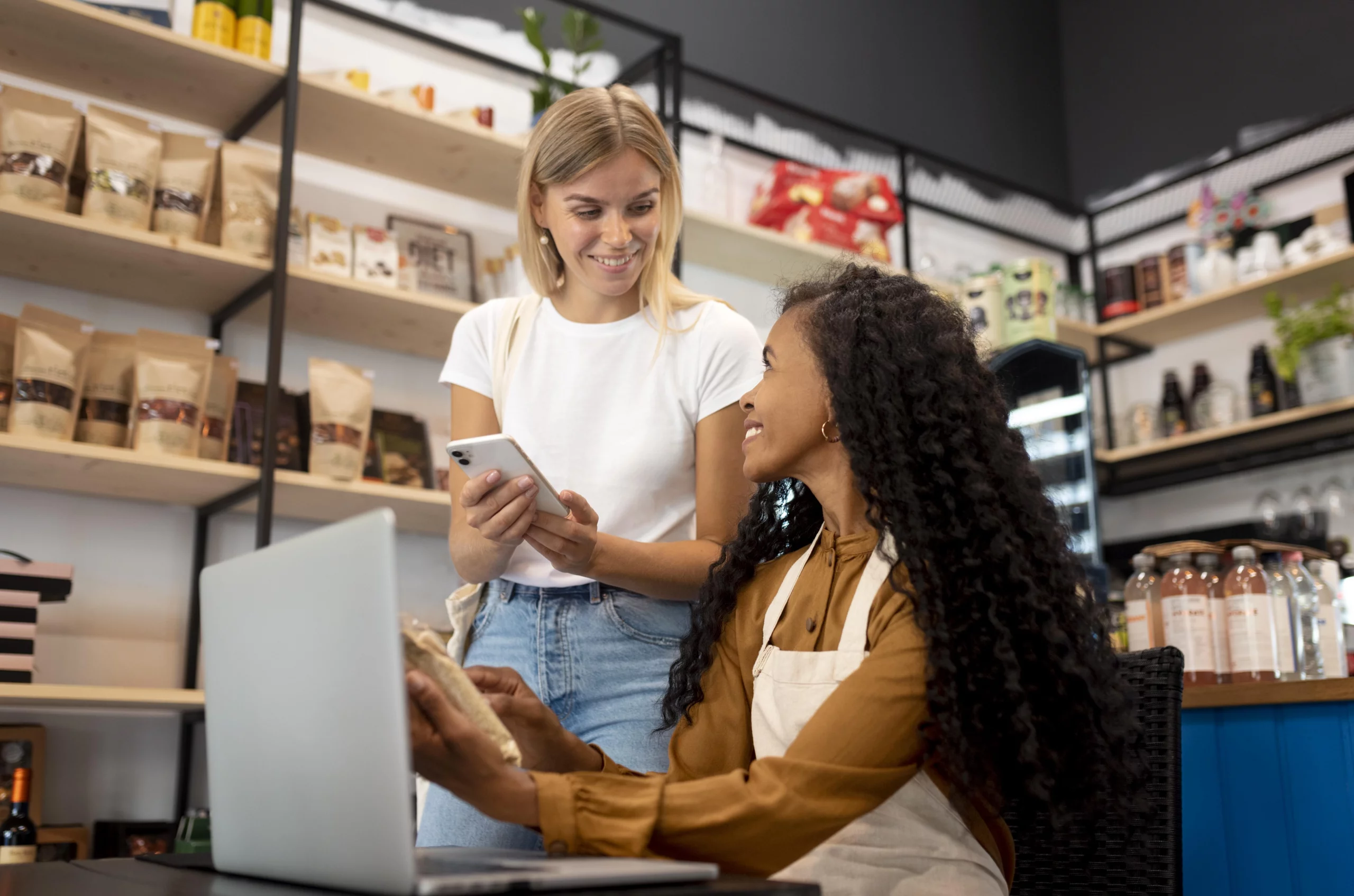Deux femmes souriantes échangent sur une stratégie commerciale lors d’une formation Qualiopi.